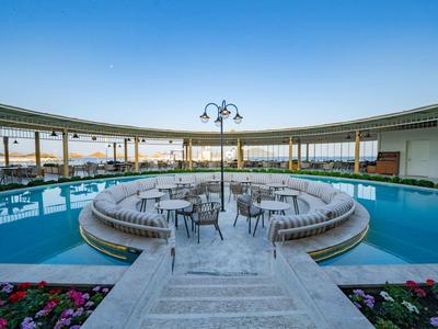 Circular pool with seating area in the center and sunset view.