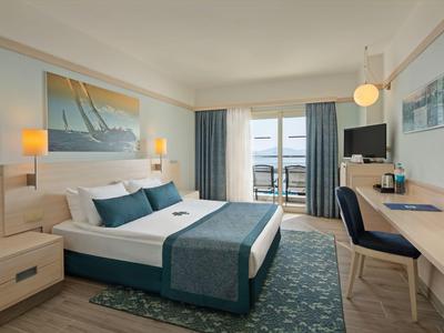 Modern eingerichtetes Hotelzimmer mit Doppelbett, Balkon und Meerblick.