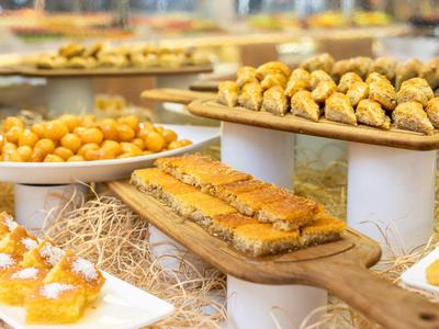 Verschiedene orientalische Süßigkeiten auf Tabletts in einem Buffet.