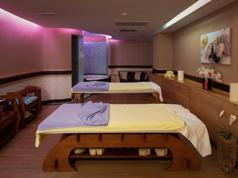 Modern massage room with soft lighting and two massage tables.