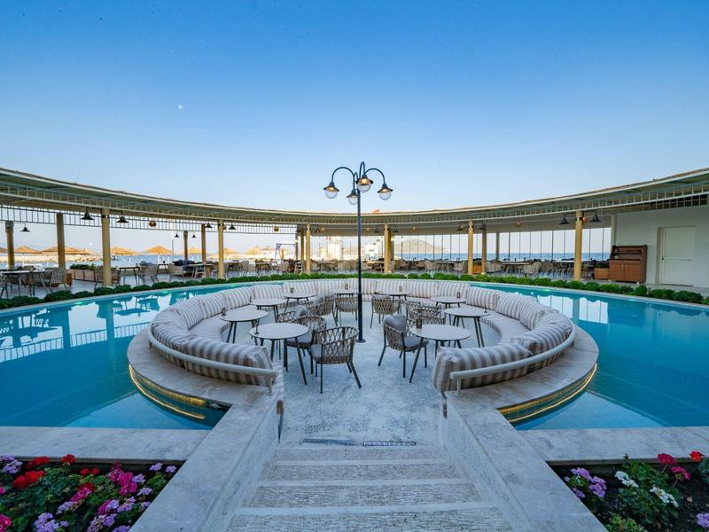 Circular pool with seating area in the center and sunset view.