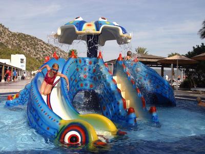 Children enjoy a colorful octopus-shaped water playground in a hotel pool.