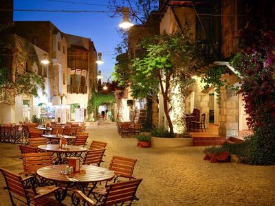 Cozy outdoor dining area on a cobblestone square at evening light