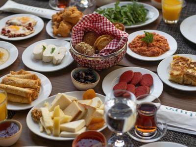Table with a diverse breakfast spread including fresh fruit, pastries, cheese, and drinks.