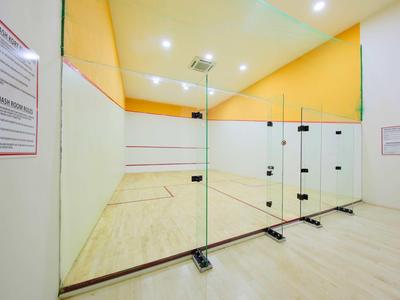Ein moderner Squash-Court mit klaren Glaswänden und hellem Holzfußboden.