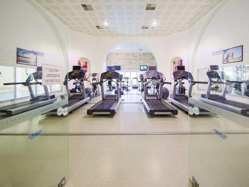 Palestra luminosa con più tapis roulant e grandi specchi alle pareti.