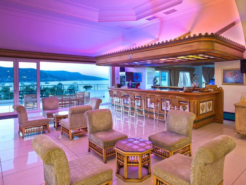 Bar d'hotel elegante con poltrone accoglienti e vista mare al crepuscolo.