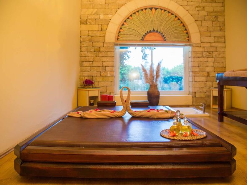 Area massaggi accogliente con materassini, candele e atmosfera tranquilla.