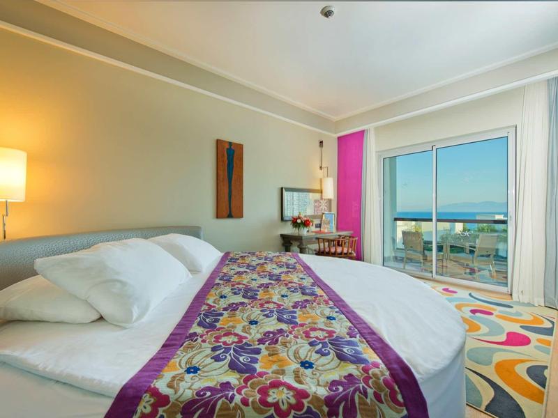 Lichte hotelkamer met groot bed, decoratieve loper en raam met uitzicht op de stad