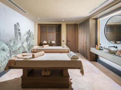 Moderner Wellnessraum mit zwei Massageliegen und dezenter Wanddekoration.