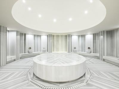 Moderner, runder türkischer Hamam mit weißen und grauen Fliesen und zentralem Wasserbecken.