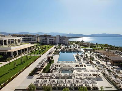 Moderner Hotelkomplex mit großen Pools und Blick auf das Meer bei klarem Wetter.