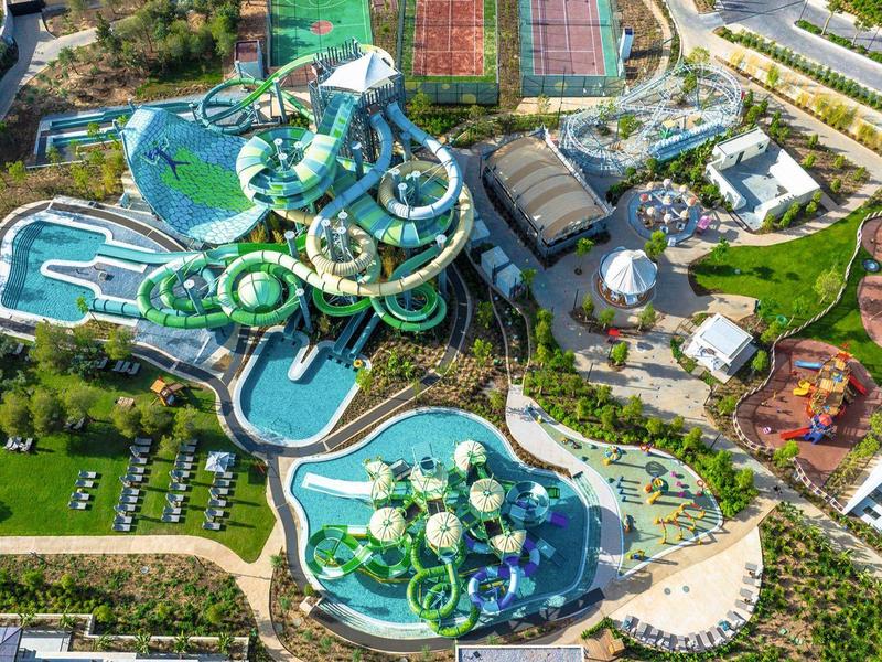Zdjęcie z lotu ptaka parku wodnego z wieloma zjeżdżalniami i basenami w ośrodku hotelowym.