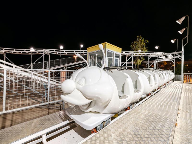 mały pociąg w parku rozrywki w kształcie białej pszczoły w nocy