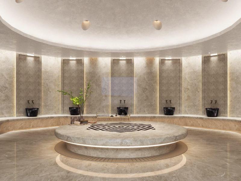 Elegancka strefa wellness z okrągłą marmurową wanną i delikatnym oświetleniem