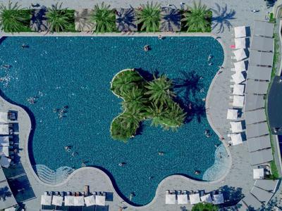 Widok z lotu ptaka na basen z tropikalną wyspą i leżakami w ośrodku.