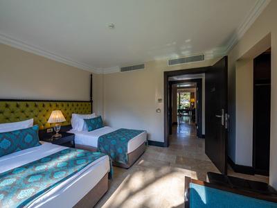 Nowocześnie urządzony pokój dwuosobowy z dwoma łóżkami i zielonym wystrojem w hotelu.