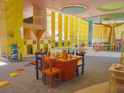 Kinderspielzimmer mit bunten Möbeln und Lernspielen in einem Hotel.