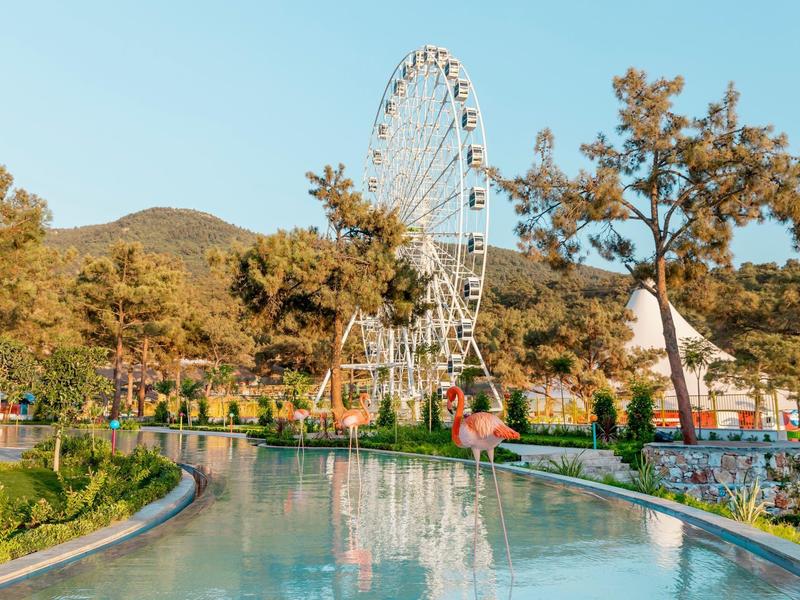 Diabelski młyn obok kanału wodnego z drzewami i górami w tle.