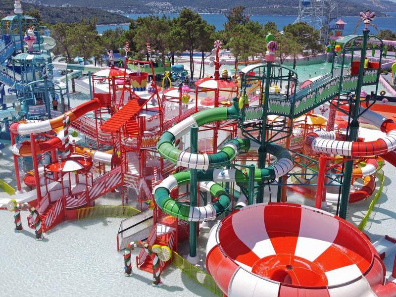 Duży park wodny z kolorowymi zjeżdżalniami i basenami przy plaży