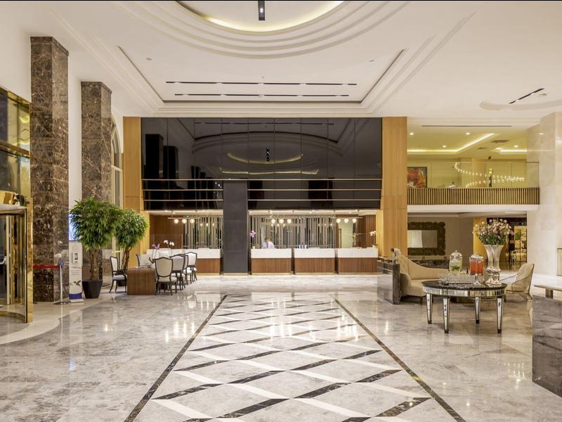 Luksusowa lobby hotelowa z marmurową podłogą, eleganckimi miejscami do siedzenia i nowoczesnym designem.