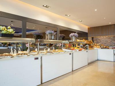 Bufet z różnymi potrawami w nowoczesnej restauracji z jasnym wnętrzem.