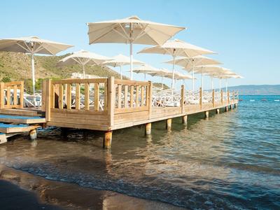 Drewniany pomost z parasolami na spokojnym jeziorze pod niebieskim niebem