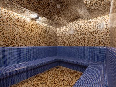 A room with blue mosaic seating and brown-beige patterned walls and floor.