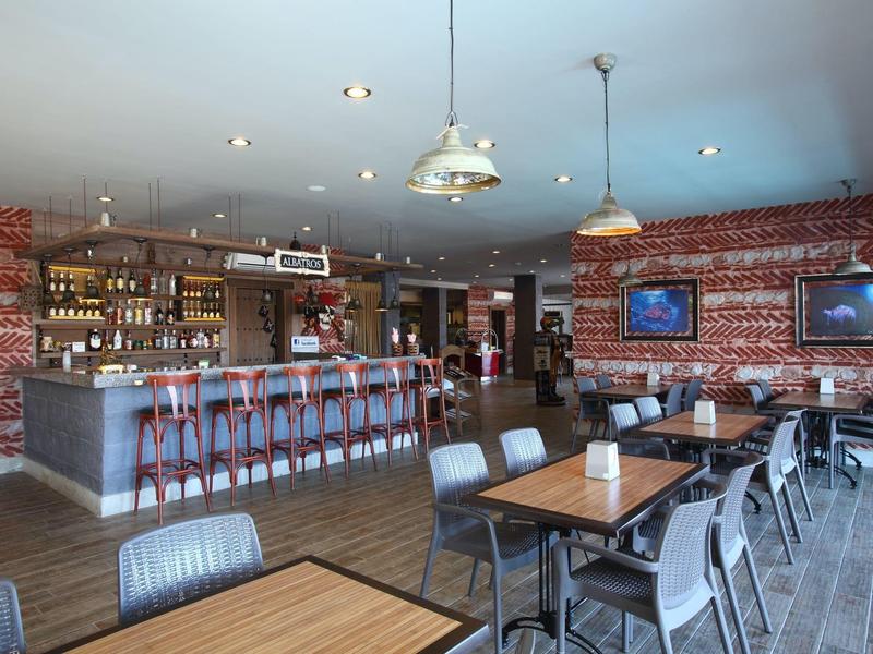 Bar moderna con muchas sillas en la barra y mesas, paredes de ladrillo rojo.