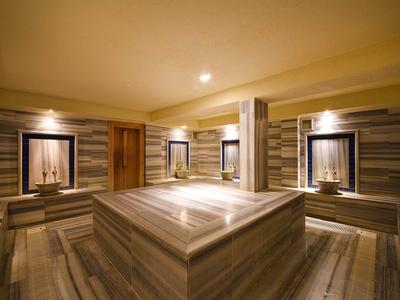 Salle de vapeur moderne avec sièges et éclairage doux dans des tons marron atténués.
