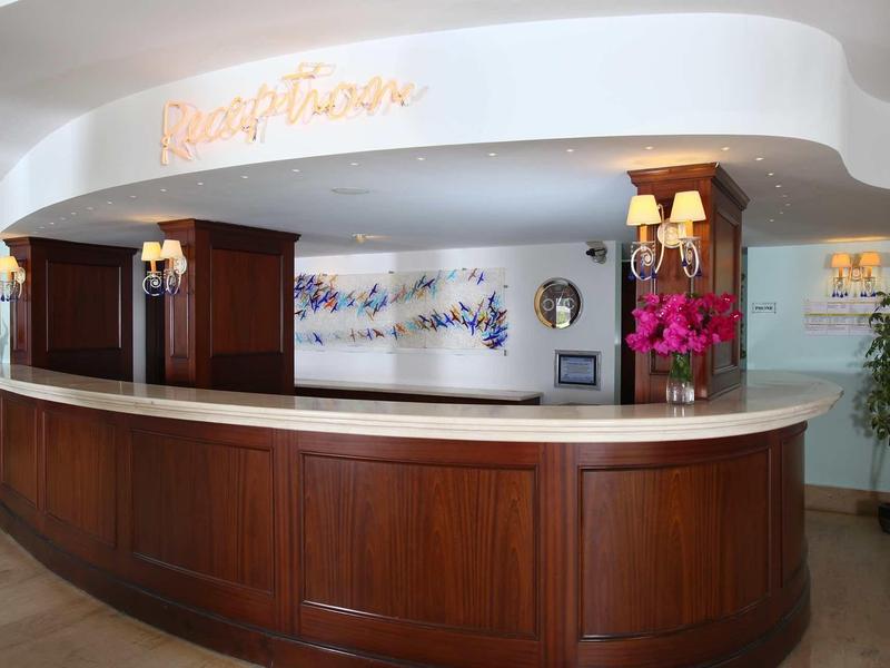 Réception d'hôtel en bois élégant avec décor floral et éclairage.