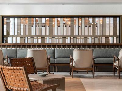 Intérieur moderne d'un salon avec chaises tissées et canapé gris.