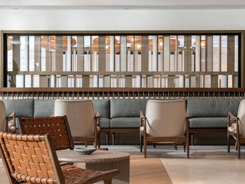 Intérieur moderne d'un salon avec chaises tissées et canapé gris.