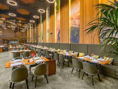 Modern restaurant with elegant chairs, large windows, and warm lighting.