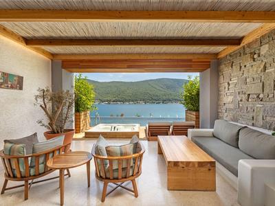Bright seating area with wooden details and a view of a lake with mountains.