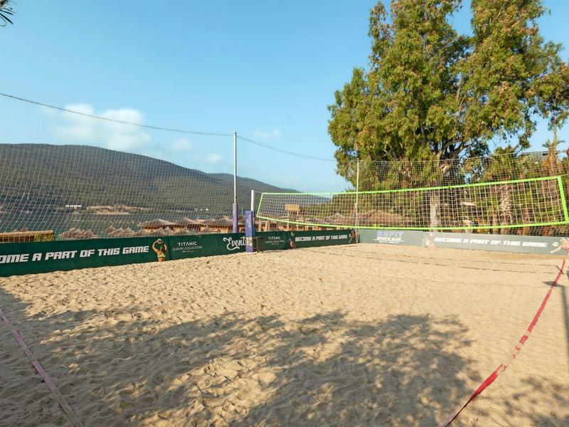 Outdoor sand volleyball court with mountains and trees in the background