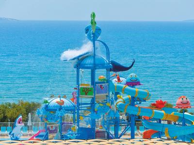 Bunter Wasserspielplatz mit Rutschen am Meer, ideal für Familienurlaub am Hotel.