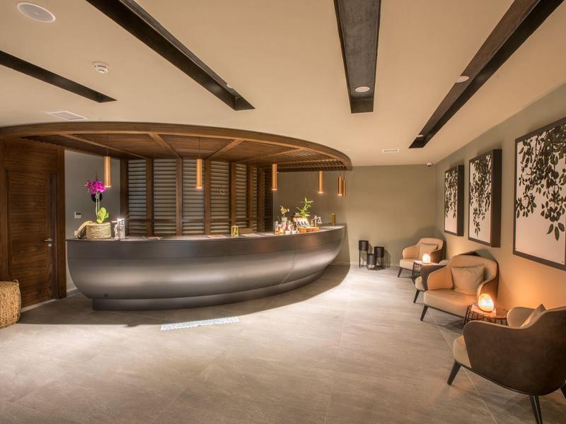 Stylová hotelová recepce s moderním nábytkem a květinovou výzdobou.