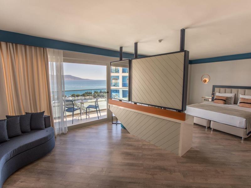 Moderní hotelový pokoj s výhledem na moře a balkonem.