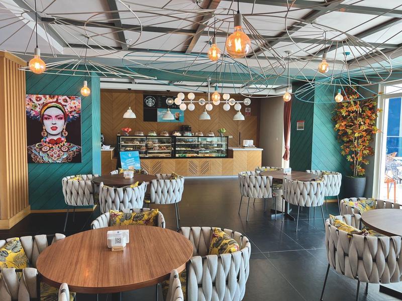 Moderní jídelna s kulatými stoly a elegantními židlemi, útulná výzdoba.