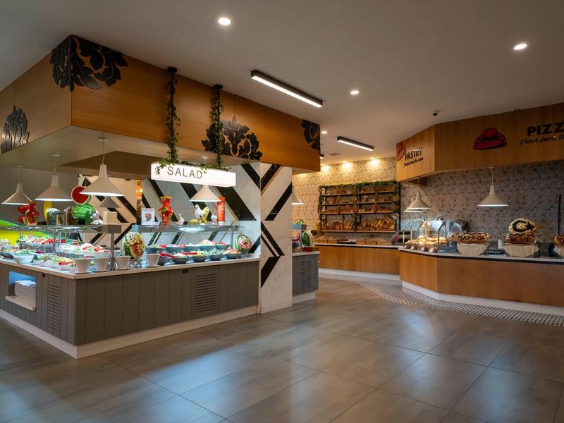 Moderní bufet s různými dezerty v světlém a prostorném prostoru.