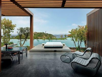 Zona exterior moderna con muebles lounge con vistas al mar y a una pequeña isla.