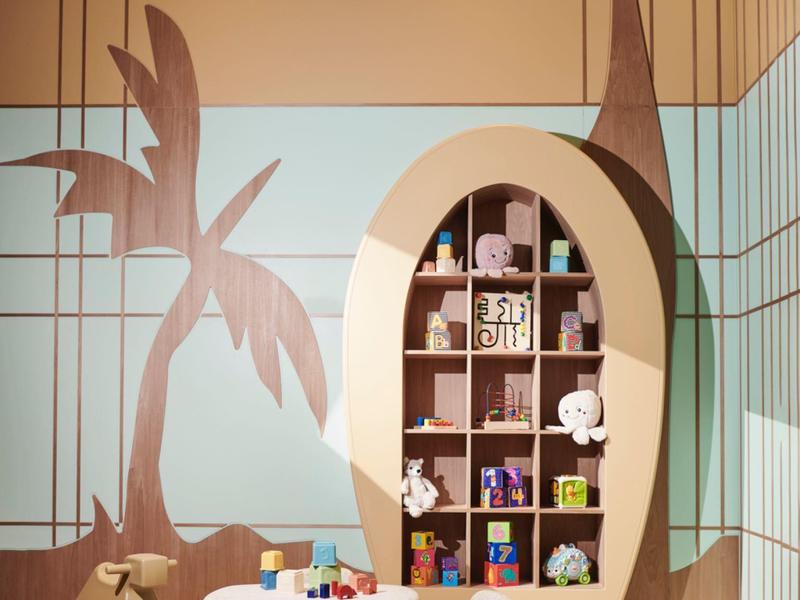 Área de juegos infantiles con mesa, sillas y mural de pared con tema animal.