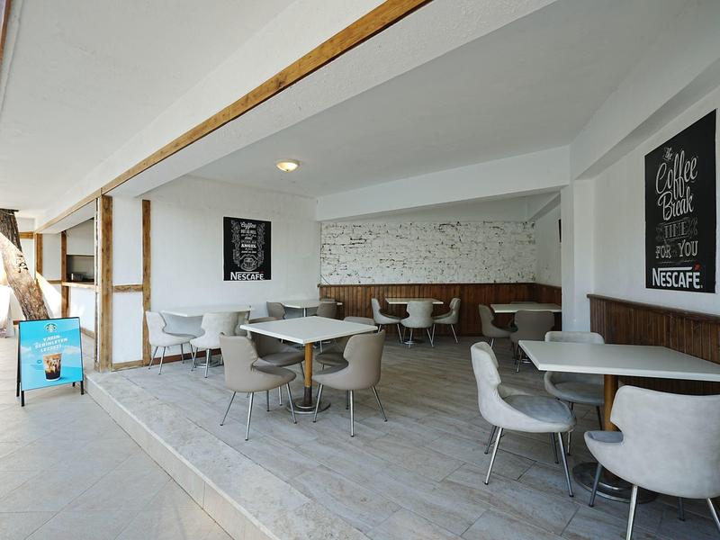 Nowoczesna przestrzeń do siedzenia w hotelu z wygodnymi krzesłami i stołami, jasne i otwarte wnętrze.