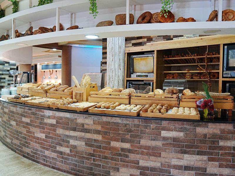 Lada z różnorodnymi świeżo wypieczonymi chlebami i wypiekami w piekarni lub hotelu.