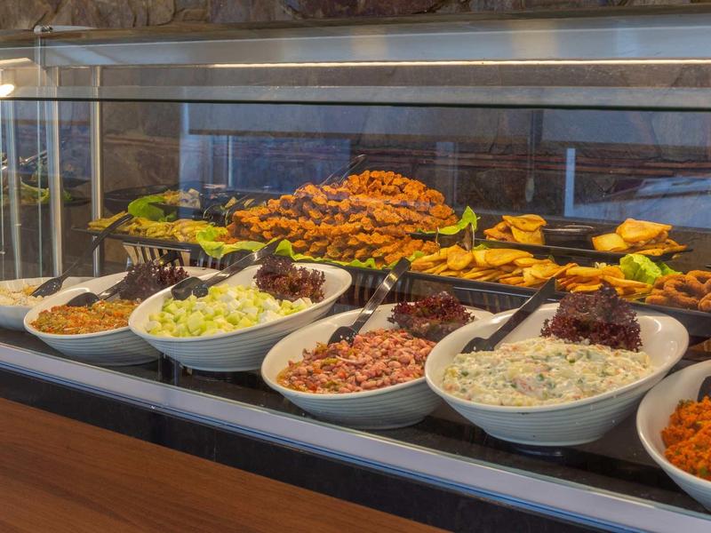 Buffet with various hot and cold dishes presented in white bowls and trays.