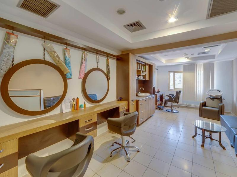 Interior of a modern hair salon with two round mirrors and chairs.