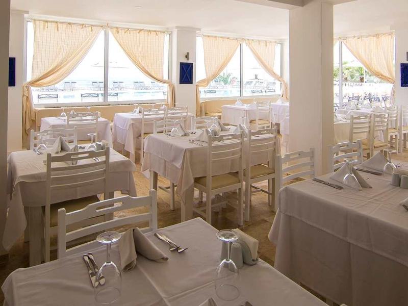 Ristorante luminoso ed elegante con tavoli bianchi e vista sulla terrazza.