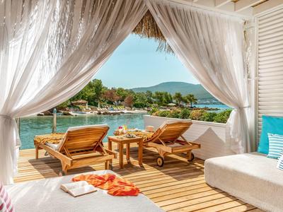 Terrace with loungers overlooking the sea and hills on a sunny day