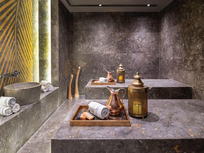 Elegant spa room with sleek stone tables and soft indirect lighting.